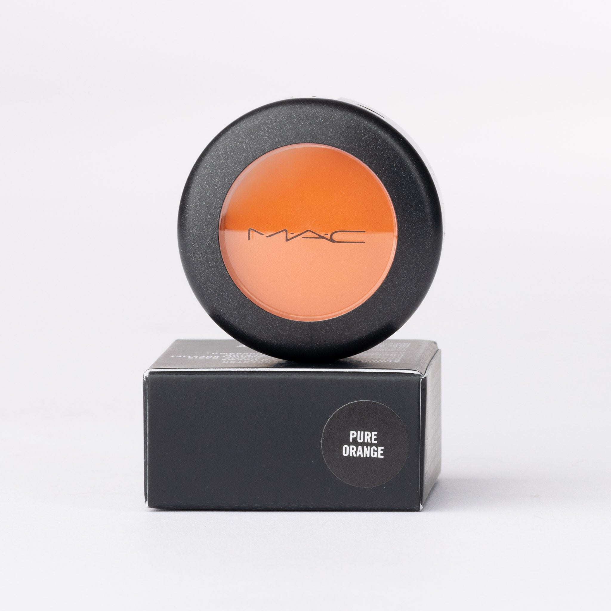 MAC Pure Orange pigment: round black compact, clear lid reveals a vibrant orange colour.